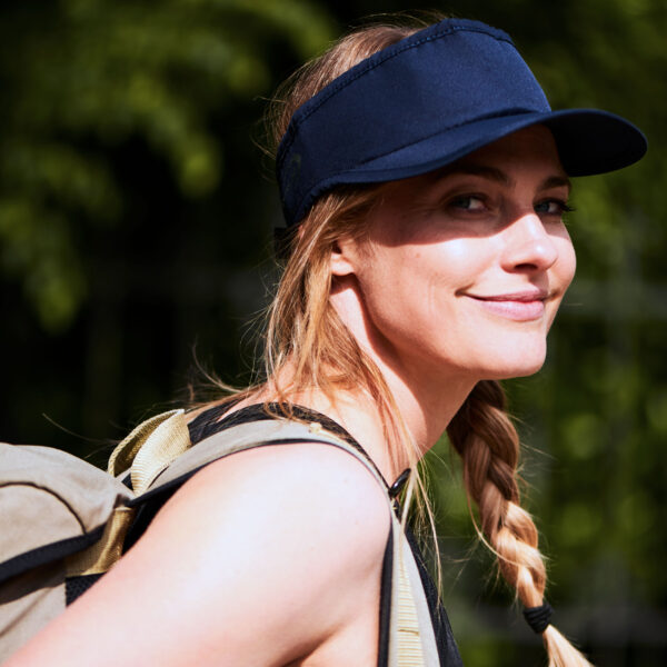 Sporty woman wears cooling sun shield by E.COOLINE in color blue