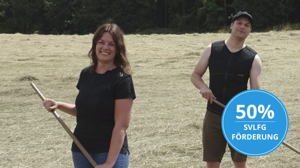 Junge Frau und junger Mann mit E.COOLINE Kühlwesten bei der Heuernte in der Landwirtschaft. Button 50% SVLFG Förderung